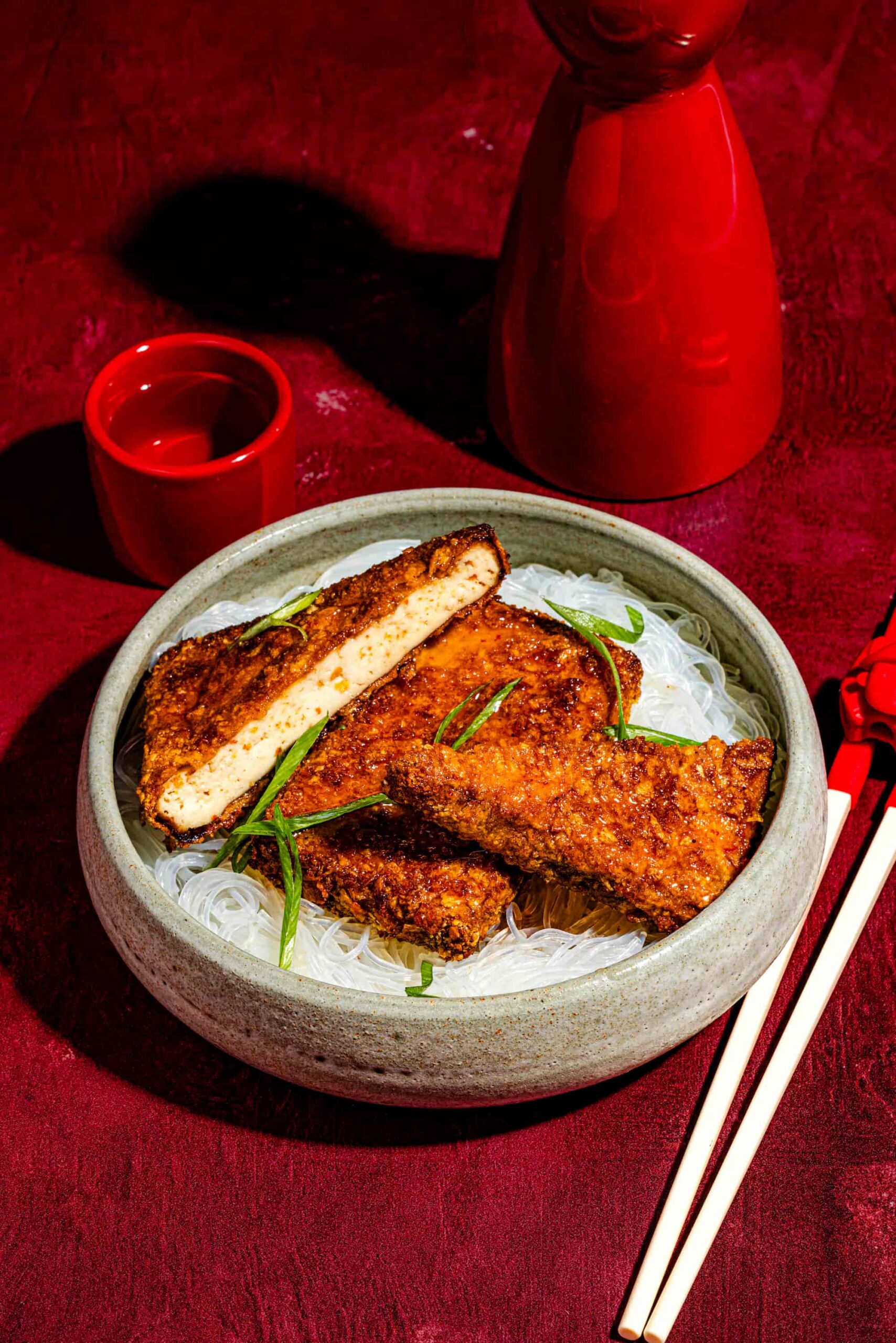 Tranches de tofu asiatique croustillant au miel épicé garnies d’oignons verts et de sésame