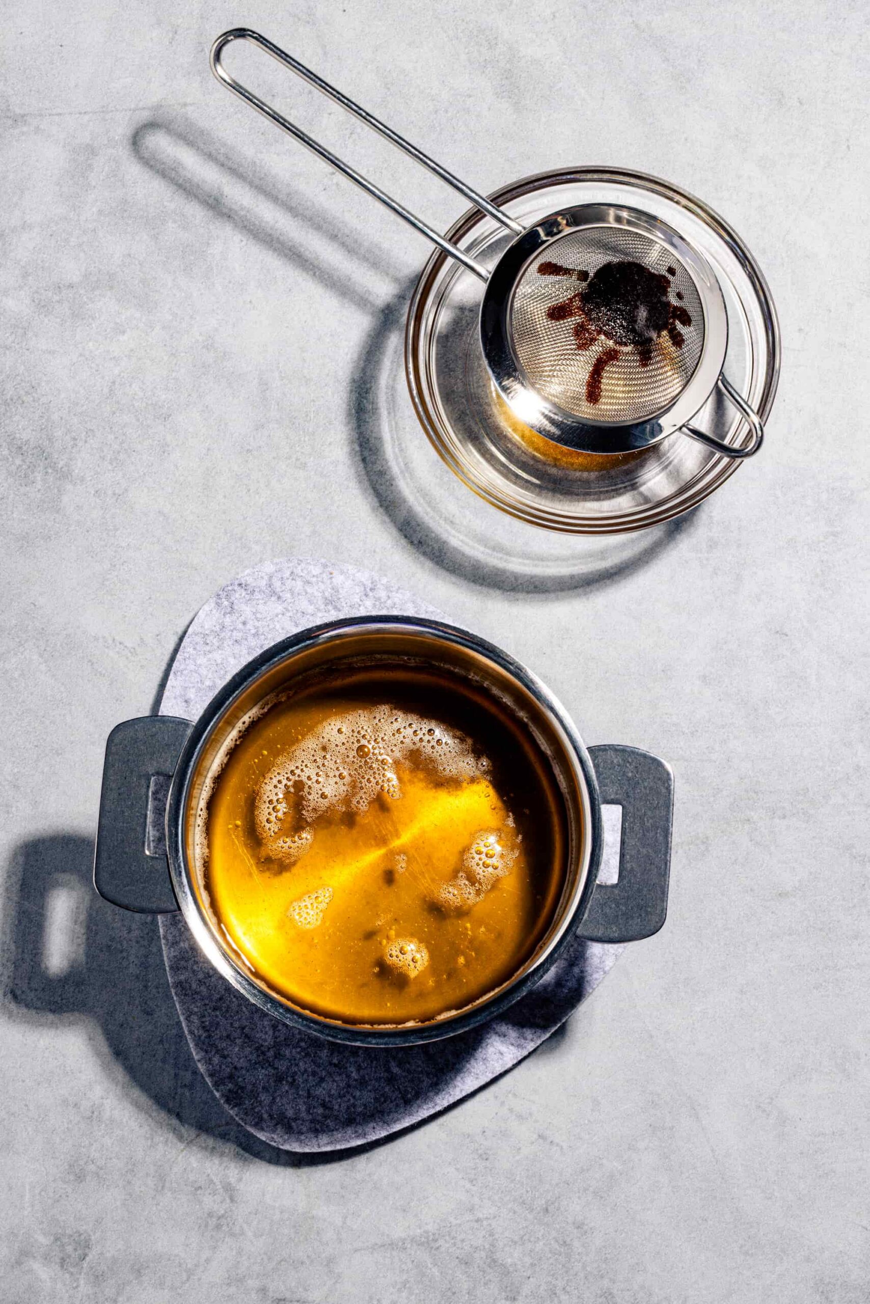 Beurre noisette maison doré dans une casserole pâle avec ses dépôts grillés