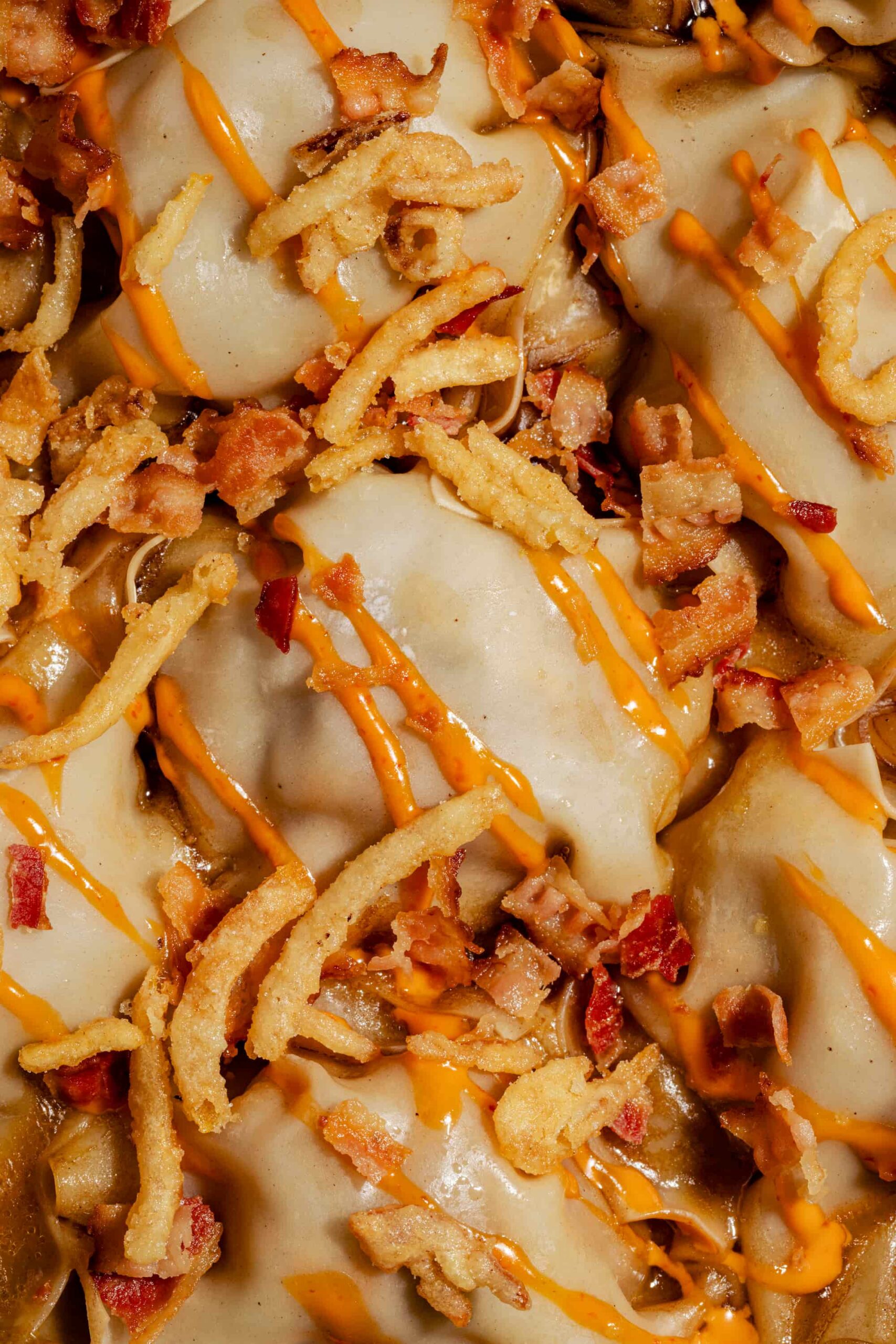 Dumplings rapides à la poêle façon cheeseburger, dorés et garnis de bœuf haché et de fromage fondant, servis dans une poêle bleue.