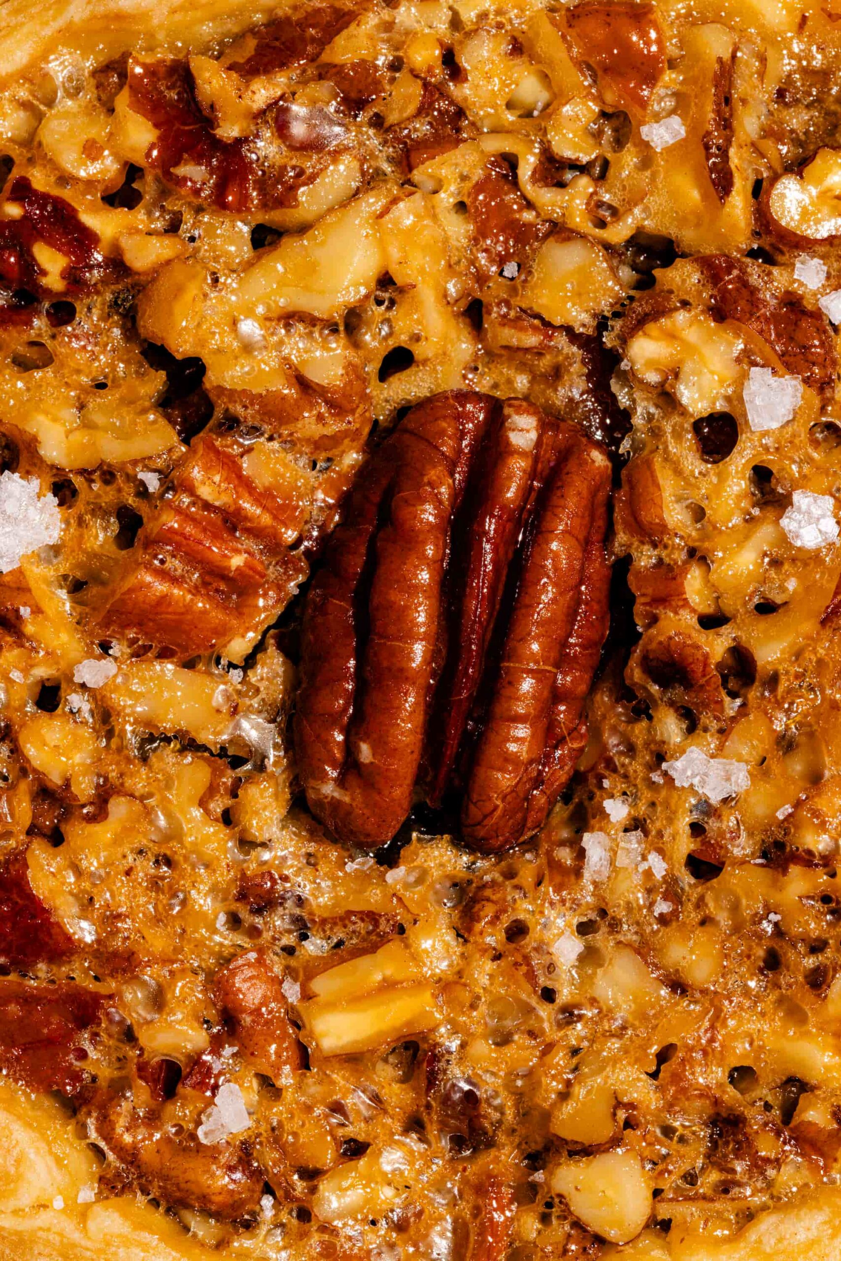 Tartelettes aux pacanes et caramel salé, garnies de noix croquantes et d'une garniture fondante dans une pâte dorée