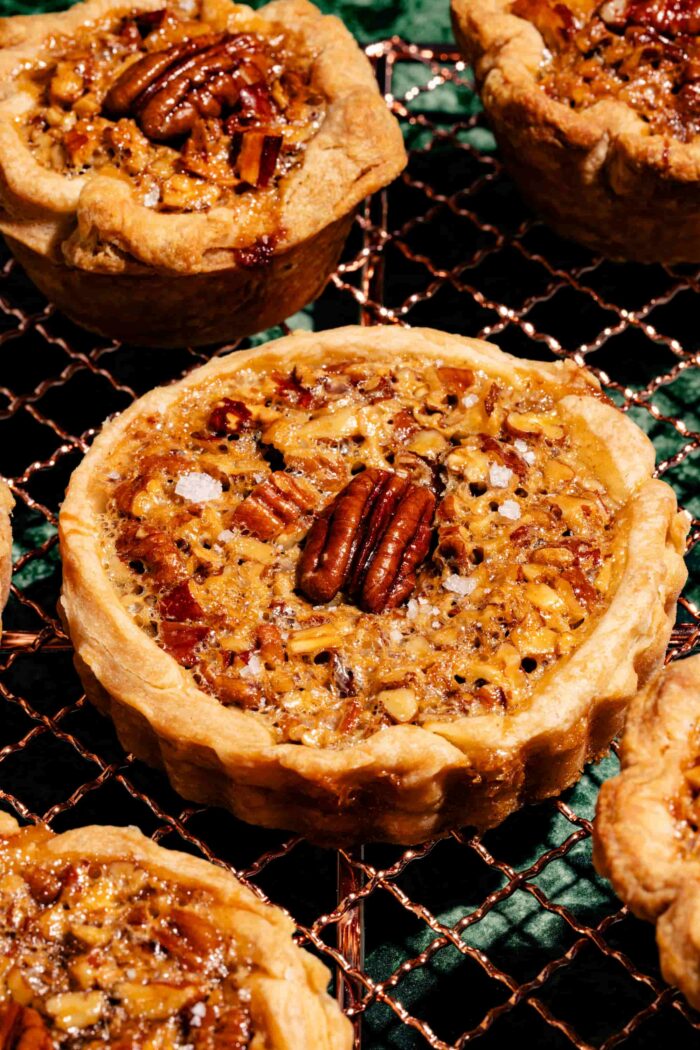 Tartelettes aux pacanes et caramel salé, garnies de noix croquantes et d'une garniture fondante dans une pâte dorée